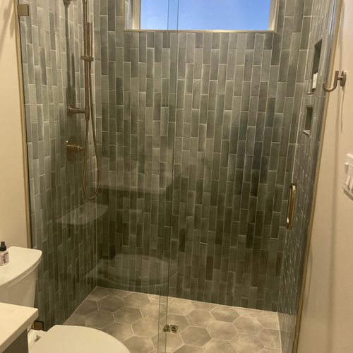Shower enclosure with tiles and glass doors by Dunn's Flooring Depot