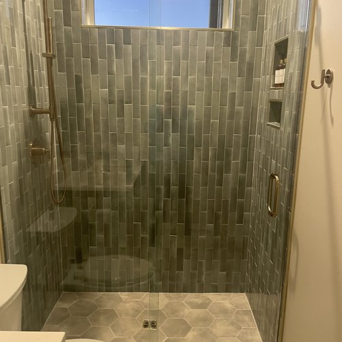 Shower enclosure with tiles and glass doors by Dunn's Flooring Depot